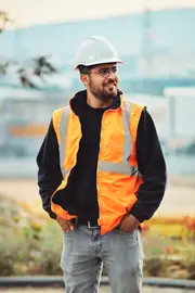 Smiling worker in a hard hat and safety vest