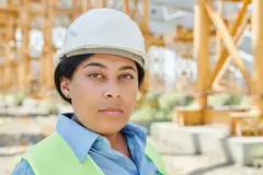 Worker in a white hard hat and safety vest