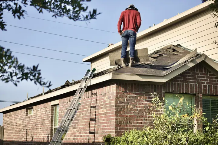 Roofer on a brick home during a roof tear-off