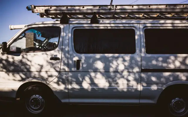 White work van with a ladder rack